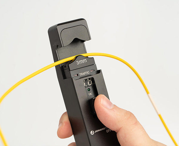 Optical Fiber Identifier - Black tool in use on yellow wire - Primus Cable